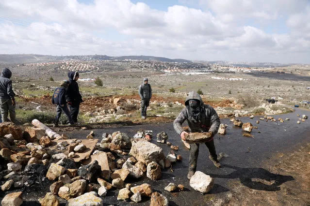 A pro-settlement activists holds a rock during an operation to evict residents from Israeli settler outpost of Amona in the occupied West Bank February 1, 2017. (Photo by Ronen Zvulun/Reuters)