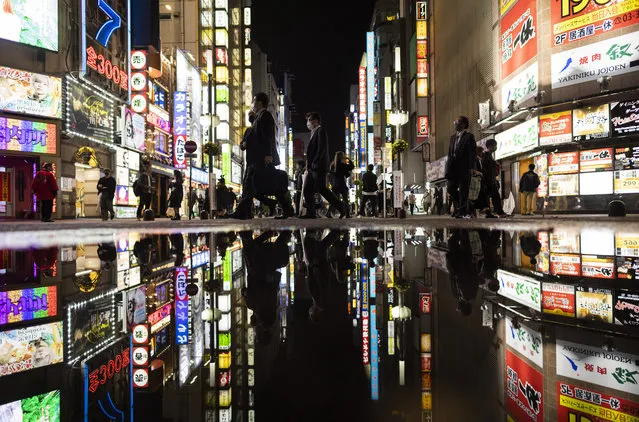 People walk through the famed Kabukicho entertainment district of Tokyo on the first night of the government’s lifting of a coronavirus state of emergency Friday, October 1, 2021. (Photo by Hiro Komae/AP Photo)