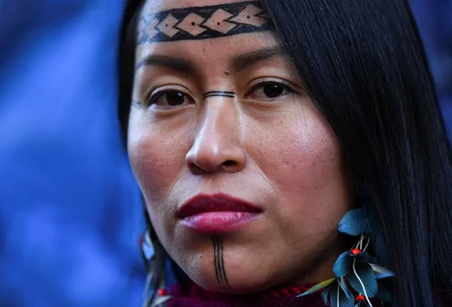 An indigenous woman takes part in a protest outside JP Morgan during the UN Climate Change Conference (COP26) in Glasgow, Scotland, Britain, November 10, 2021. (Photo by Dylan Martinez/Reuters)