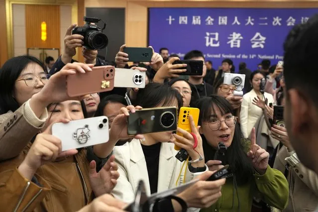 Chinese journalists mob a foreign journalist at the end of the Chinese Foreign Minister's press conference on the sideline of the National People's Congress in Beijing, Thursday, March 7, 2024. (Photo by Ng Han Guan/AP Photo)