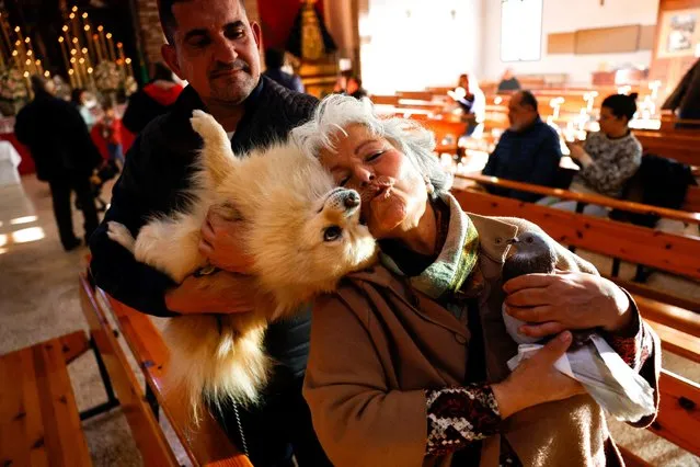 A woman and a man react with their pigeon Luckito, 6, and their dog, Lucky, 10, before they are blessed with holy water at San Antonio Abad Church during celebrations on the feast of Spain's patron saint of animals, Saint Anthony, in the neighborhood of Churriana, in Malaga, Spain, January 17, 2023. (Photo by Jon Nazca/Reuters)