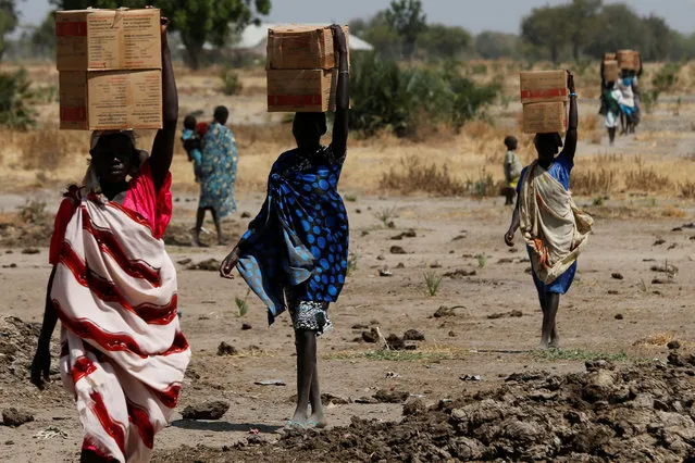 Women carry boxes of nutritional food delivered by the United Nations World Food Programme (UN WFP), in Rubkuai village, Unity State, South Sudan February 16, 2017. (Photo by Siegfried Modola/Reuters)
