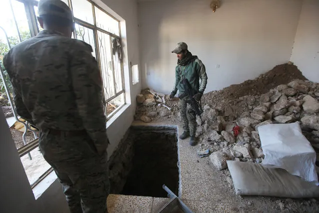 Iraq's Rapid Response forces peer down a tunnel dug by Islamic State militants in a house in Albu Saif, south of Mosul, Iraq February 21, 2017. (Photo by Alaa Al-Marjani/Reuters)