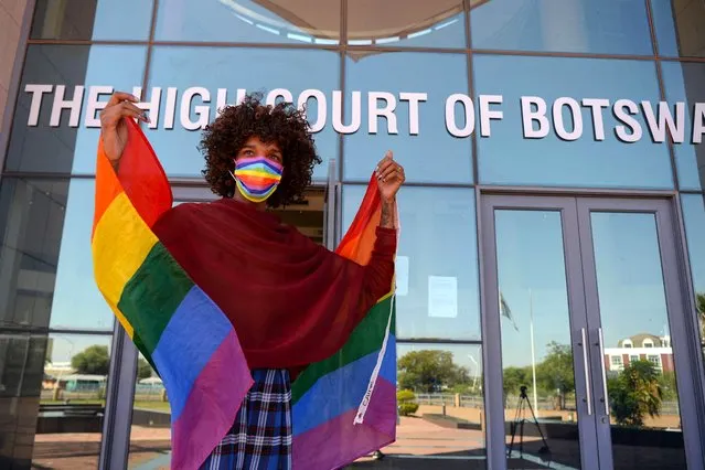 An activists holds a rainbow flag outside the Botswana High Court in Gaborone on November 29, 2021 celebrating after the Botswana Court of Appeal dismissed the appeal by the government of Botswana against the Botswana High Court ruling of decriminalising homosexuality. Botswana's government on November 29, 2021 lost a legal attempt to overturn a landmark ruling that decriminalised homosexuality The country's High Court in 2019 ruled in favour of campaigners seeking to strike do jail sentences for same-sеx relationships, declaring them unconstitutional. (Photo by Monirul Bhuiyan/AFP Photo)