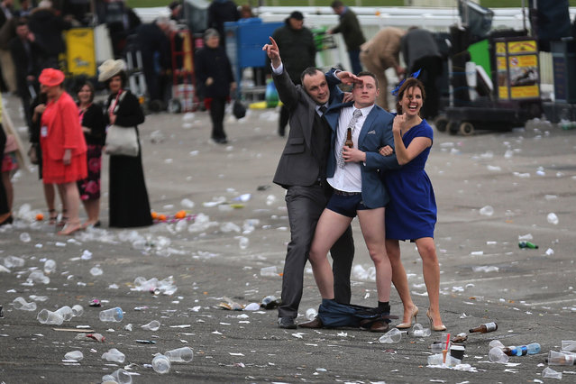 A man plays to the cameras as racegoers make their way home at the end of Ladies Day the second day of the Aintree Grand National Festival meeting on April 8, 2016 in Aintree, England. Today is Fabulous Friday and Ladies Day of the three-day meeting of the world famous Grand National Festival where fashion and dressing to impress is as important as the racing. (Photo by Christopher Furlong/Getty Images)