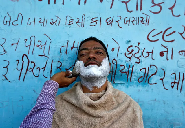 A man gets a shave from a roadside barber in Ahmedabad, India February 27, 2017. (Photo by Amit Dave/Reuters)