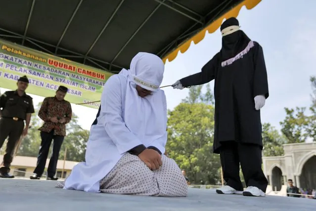 An Acehnese woman is being whipped in front of the public for violating the sharia law in Banda Aceh, Indonesia, March 7, 2017. The woman was sentenced to 100 lashes for having s*x without being married. Aceh is the only province in Indonesia which has implemented the sharia law that bans the relationship between a woman and a man if they are not legally married. Whipping is one form of punishment imposed in Aceh for violating the Islamic Sharia law. (Photo by Hotli Simanjuntak/EPA)