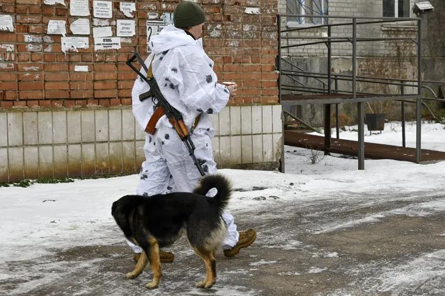 A Ukrainian serviceman patrols a street near frontline with with Russia-backed separatists in Verkhnotoretske village in Yasynuvata district, Donetsk region, eastern Ukraine, Saturday, January 22, 2022. Russia on Thursday announced sweeping naval drills in several parts of the world this month, and claimed the West is plotting “provocations” in neighboring Ukraine where the Kremlin has been accused of planning aggressive military action. (Photo by Andriy Andriyenko/AP Photo)