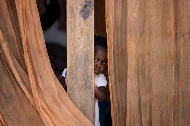 A girl displaced by gang war violence looks on at the Antenor Firmin high school transformed into a shelter, where people live in poor conditions, in Port-au-Prince, Haiti on May 1, 2024. (Photo by Ricardo Arduengo/Reuters)