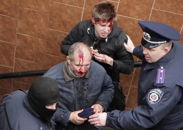 Interior Ministry members stand near men, who were injured in clashes between pro-Russian and pro-Ukrainian supporters during their rallies, in Kharkiv, April 13, 2014. (Photo by Reuters/Stringer)