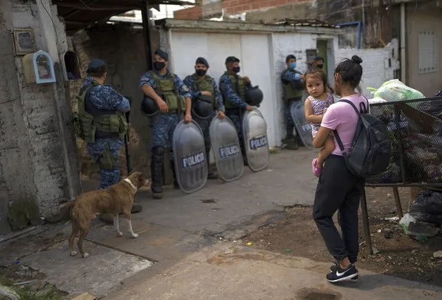 Riot policemen stand guard during an operation in the Villa Sarmiento shanty town in Buenos Aires, Argentina, Thursday, February 3, 2022, where it is believed people may have purchased contaminated cocaine. A batch of cocaine that has killed at least 20 people in Argentina appears to have been laced with a synthetic opioid, and police are scrambling to get as much of it off the streets as they can. (Photo by Rodrigo Abd/AP Photo)