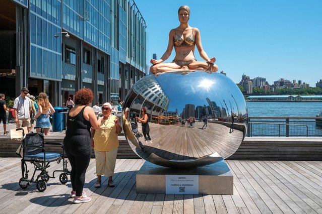 People visit an installation by the American sculptor, Carole Feuerman, during the exhibition of her hyperrealistic sculptures at Pier 17 in the trendy neighbourhood of Seaport in New York City on June 1, 2024. (Photo by Milo Hess/ZUMA Press Wire/Rex Features/Shutterstock)