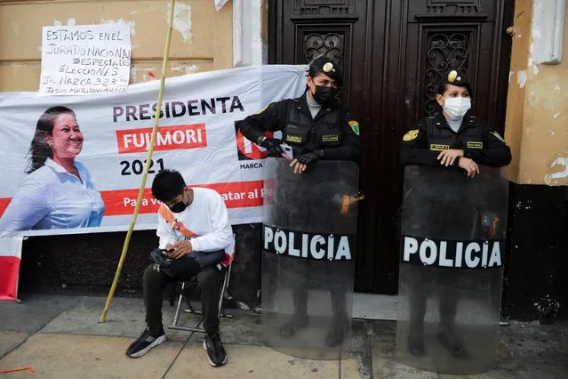 Police officers stand guard as supporters of Peru's presidential candidate Keiko Fujimori gather in Lima, Peru on June 15, 2021. (Photo by Sebastian Castaneda/Reuters)