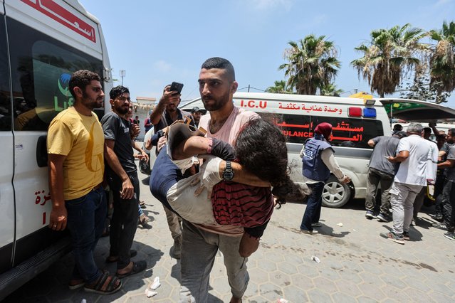 A Palestinian man carries a casualty in the aftermath of an Israeli strike, amid the Israel-Hamas conflict, at Al-Aqsa Martyrs Hospital in Deir Al-Balah, in the central Gaza Strip, on June 8, 2024. (Photo by Ramadan Abed/Reuters)
