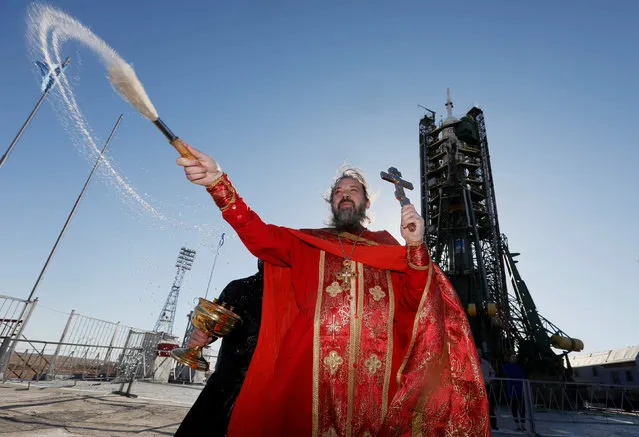 An Orthodox priest conducts a blessing in front of the Soyuz MS-04 spacecraft set on the launchpad ahead of its upcoming launch, at the Baikonur cosmodrome in Kazakhstan, April 19, 2017. (Photo by Shamil Zhumatov/Reuters)