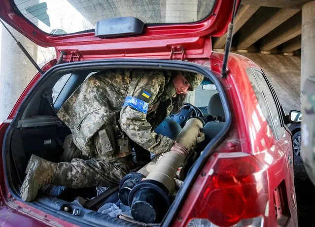Tetiana Chornovol, former member of the Ukrainian Parliament, now a service member and operator of an anti-tank guided missile weapon system, pulls an anti-tank missile out of a car at a position on the front line, amid Russia's invasion of Ukraine, in the Kyiv region, Ukraine on March 20, 2022. (Photo by Gleb Garanich/Reuters)