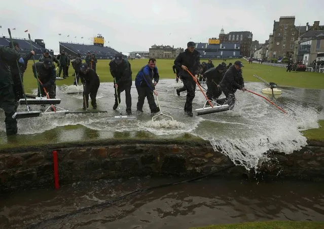 Groundstaff remove water from the course after torrential rain forced play to be suspended during the second round of the British Open golf championship on the Old Course in St. Andrews, Scotland, July 17, 2015. (Photo by Lee Smith/Reuters)