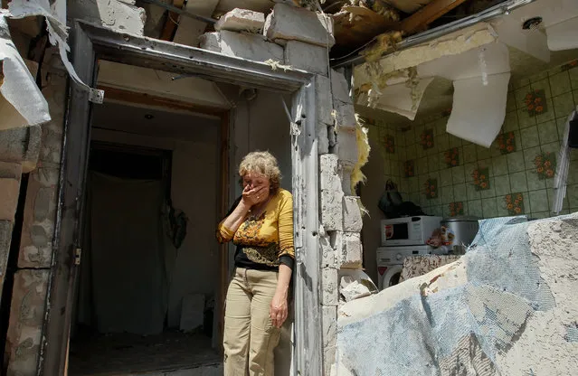 A local woman reacts next to her destroyed home after shelling in pro-Russian rebels controlled Staromykhaylivka village near of Donetsk, Ukraine, 24 May 2016. Russia argues the upgraded OSCE mission should be deployed on the demarcation line in Donbas but not on the border between Russia and Ukraine according to a statement of Kremlin spokesman Dmitry Peskov in Moscow. (Photo by Alexander Ermochenko/EPA)