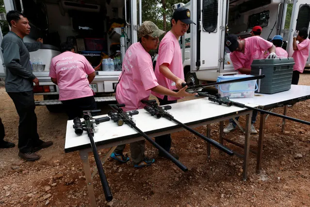 Officials prepare weapons with a sedation as they start moving tigers from Thailand's controversial Tiger Temple, a popular tourist destination which has come under fire in recent years over the welfare of its big cats in Kanchanaburi province, west of Bangkok, Thailand, May 30, 2016. Wildlife authorities raid a Buddhist temple that has more than 100 tigers, taking away three cats and vowing to confiscate scores more in response to global pressure over wildlife trafficking. (Photo by Chaiwat Subprasom/Reuters)