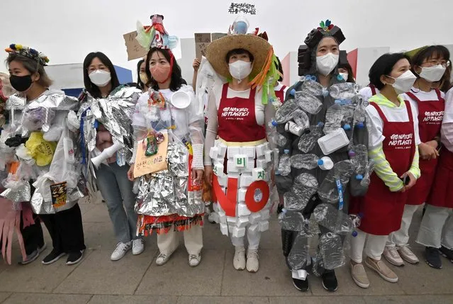 South Korean environmental activists wear outfits made of plastic waste during a campaign marking Earth Day against climate change at a park along the Han River in Seoul on April 22, 2022. (Photo by Jung Yeon-je/AFP Photo)