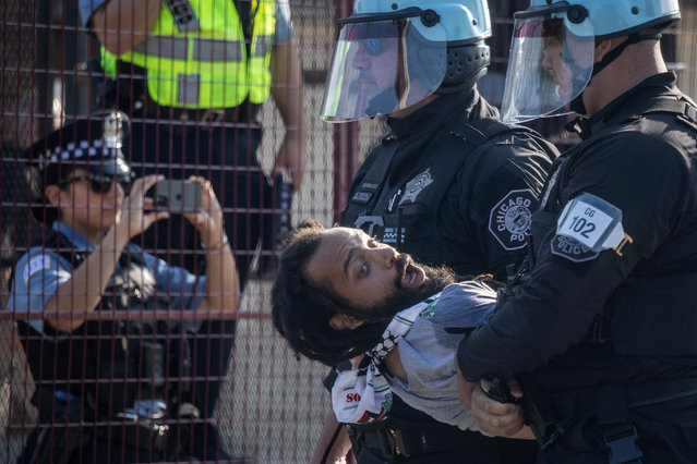 Police officers detain a man after several protesters broke through a security fence near United Center during the Democratic National Convention (DNC), in Chicago, Illinois, U.S., August 19, 2024. (Photo by Adrees Latif/Reuters)