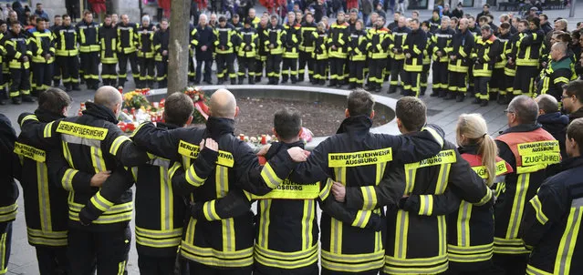 Firemen mourn at Königsplatz in Augsburg, Germany, Sunday, December 8, 2019. On the evening of Dec. 6 a fireman was so badly injured in his spare time here in an argument with a group that he died. (Photo by Stefan Puchner/dpa via AP Photo)