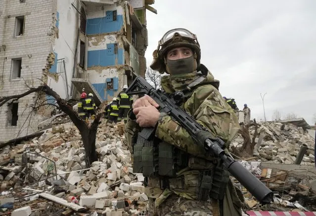 A Ukrainian soldier stands near an apartment ruined from Russian shelling in Borodyanka, Ukraine, Wednesday, April 6, 2022. (Photo by Efrem Lukatsky/AP Photo)