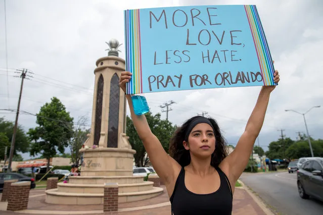 Raquel Flores, of Richardson, Texas holds up a sign at the Legacy of Love Monument on June 12, 2016 in Dallas. (Photo by Ting Shen/The Dallas Morning News via AP Photo)