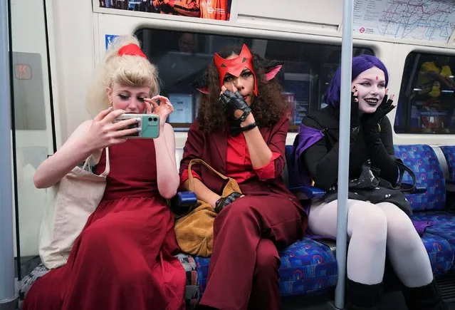 Cosplayers (left to right) Oli Hazeldine (dressed as Princess Adora from the animated series She-Ra); Val Imms (Catra from She-Ra), and Lou Frewin (Raven from the animated series Teen Titans) travelling on a Jubilee Line train heading for MCM Comic Con at the ExCel London in east London on Sunday, May 29, 2022. (Photo by Yui Mok/PA Wire)