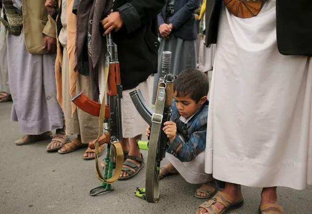 A boy holds his father's rifle during a rally by followers of the Houthi movement against the Saudi-led coalition in Yemen's capital Sanaa, August 11, 2015. Militiamen clashed with Yemen's dominant Houthi group inside the city of Ibb on Tuesday, residents said, in their latest significant advance into territory the Houthis had held unopposed for months. (Photo by Mohamed al-Sayaghi/Reuters)