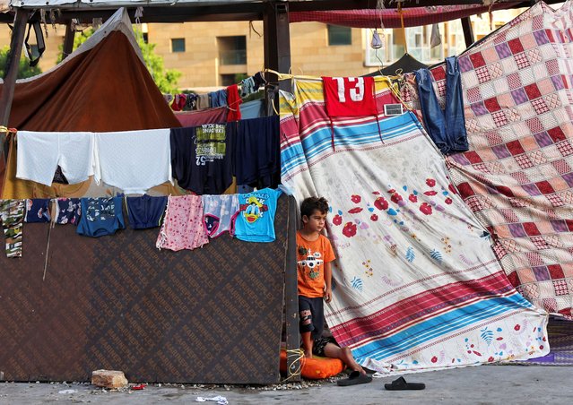 A displaced boy looks on at a makeshift encampment on the street at Beirut's central Martyrs' Square, where many families spend the night fleeing the overnight Israeli strikes in southern Beirut, in Lebanon on October 9, 2024. (Photo by Amr Abdallah Dalsh/Reuters)