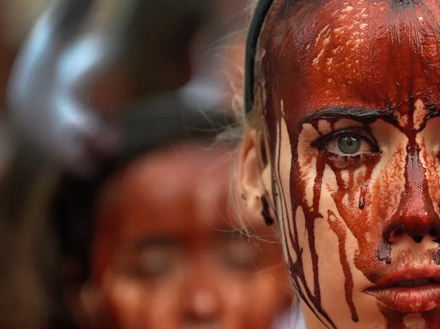 A animal rights protester covered in fake blood demonstrate for the abolition of bull runs and bullfights a day before the start of the famous running of the bulls San Fermin festival in Pamplona, northern Spain, July 5, 2016. (Photo by Eloy Alonso/Reuters)
