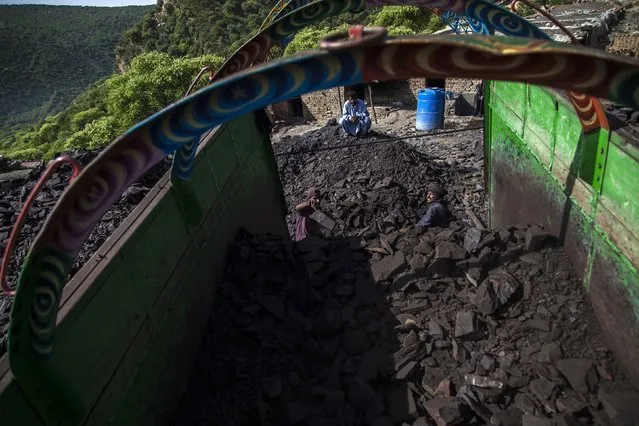 A miner loads coal onto a truck outside a mine in Choa Saidan Shah, Punjab province, April 29, 2014. (Photo by Sara Farid/Reuters)