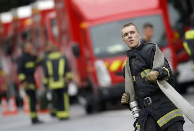 French firefighters of Paris Fire Brigade (BSPP) recover their material during operations to extinguish the fire that broke-out overnight at the Cite des Sciences et Industries Museum at La Villette, in Paris, France, August 20, 2015. More than 10,000 square meters were hit by the fire that started in an area under construction. (Photo by Christian Hartmann/Reuters)