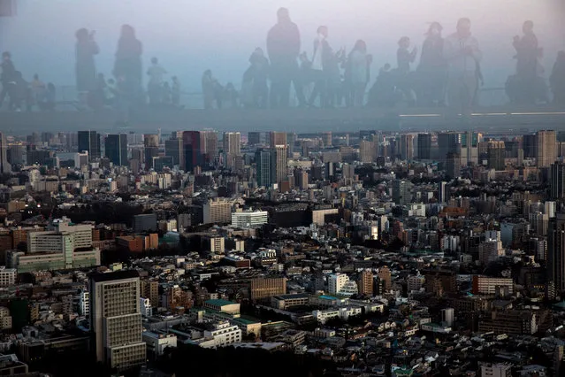 People are reflected as they observe on the Shibuya Sky observation deck in Tokyo, Japan, February 24, 2020. (Photo by Athit Perawongmetha/Reuters)