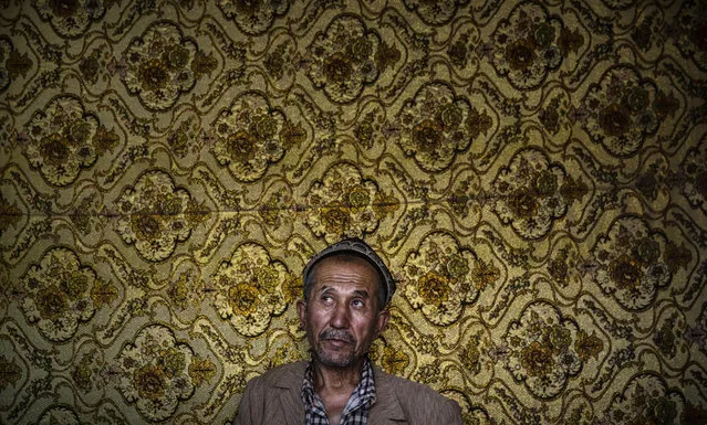 A Uyghur man waits to have his hair cut at a barber shop before the Eid holiday  on July 28, 2014 in old Kashgar, Xinjiang Province, China. (Photo by Kevin Frayer/Getty Images)