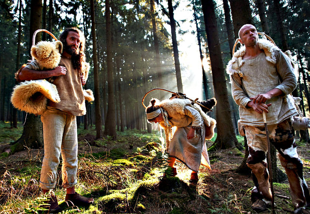 The so-called “Stone Age”-travellers (L to R) Lukas Heinen, Veronika Hocke and Marco Hocke walk in the forest near Altenbeken, western Germany, on August 21, 2015 on their way from Detmold to Bonn. The travellers wearing Stone Age clothes walk 14 days to promote the upcoming exhibition “Revolution Stone Age” that runs from September 5, 2015 to April 3, 2016 in Bonn. (Photo by Bernd Thissen/AFP Photo/DPA)