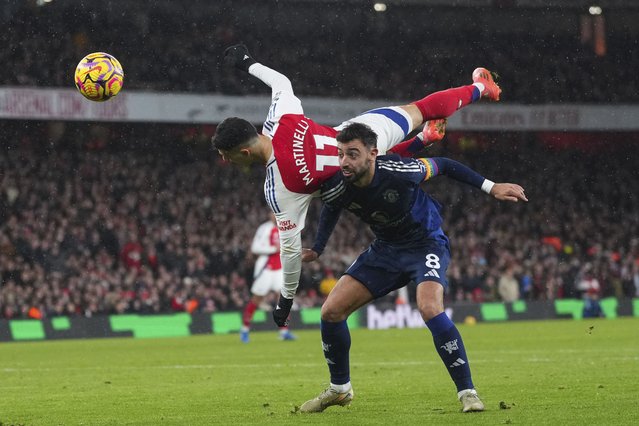 Arsenal's Gabriel Martinelli goes over Manchester United's Bruno Fernandes as they challenge the ball during the English Premier League soccer match between Arsenal and Manchester United at Emirates stadium in London, Wednesday, December 4, 2024. (Photo by Kirsty Wigglesworth/AP Photo)