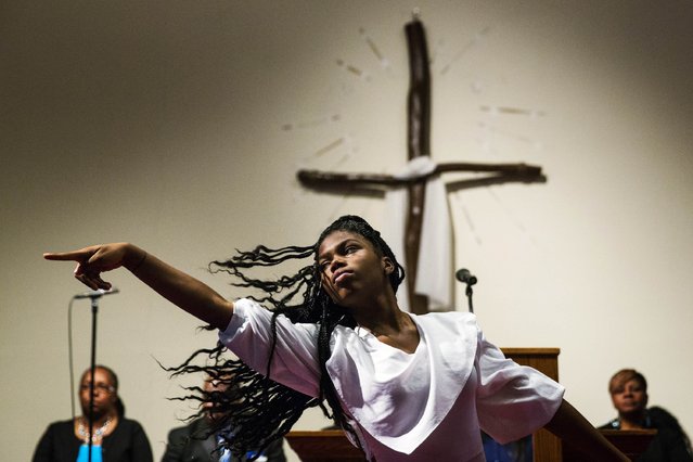 A woman dances during church services at the Greater St Mark Family Church as the community discusses reactions to the shooting of teenager Michael Brown in Ferguson, Missouri August 17, 2014. The Ferguson police department has come under strong criticism for both the shooting and its handling of its aftermath. (Photo by Lucas Jackson/Reuters)