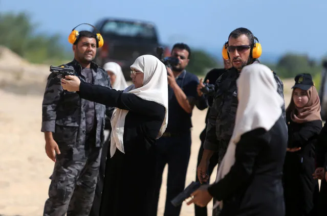 A Palestinian woman aims a pistol as she prepares to fire at a target during a training session for the families of Hamas officials, organized by Hamas-run Security and Protection Service, in Khan Younis in the southern Gaza Strip July 24, 2016. (Photo by Ibraheem Abu Mustafa/Reuters)
