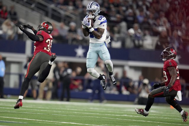Dallas Cowboys wide receiver CeeDee Lamb (88) catches a pass between Tampa Bay Buccaneers cornerback Jamel Dean (35) and Christian Izien (29) in the first half of an NFL football game in Arlington, Texas, Sunday, December 22, 2024. (Photo by Julio Cortez/AP Photo)