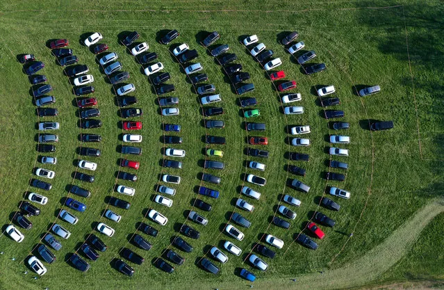 An aerial view shows cinema goers sitting in their cars parked at a drive-in cinema in Marl, western Germany, on April 6, 2020, one of the few entertainments still allowed due to the spread of the novel coronavirus COVID-19. (Photo by Ina Fassbender/AFP Photo)