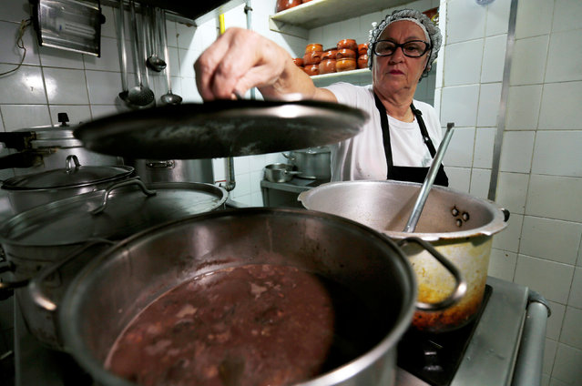 A cook prepares the Brazilian traditional dish called feijoada (black bean and meat stew) at the Bar do Mineiro in Rio de Janeiro, Brazil, March 24, 2016. (Photo by Sergio Moraes/Reuters)