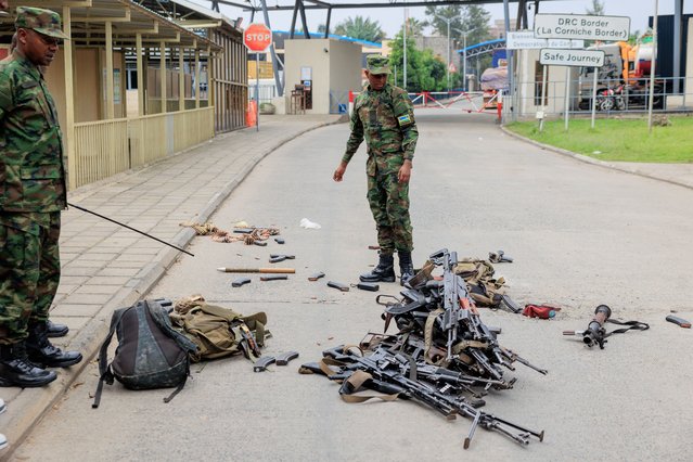 A Rwandan soldier inspects the weapons taken from surrendering members of the Armed Forces of the Democratic Republic of the Congo (FARDC) after crossing the border from Goma, in the Democratic Republic of the Congo, to Gisenyi, Rwanda, 27 January 2025. Refugees have been crossing into Rwanda in search of safety as soldiers of the Armed Forces of the Democratic Republic of the Congo (FARDC) and M23 rebels continue to fight in the city of Goma. According to the UN Refugee Agency (UNHCR), violence in the eastern Democratic Republic of the Congo (DRC) has displaced 237,000 people in 2025. (Photo by Moise Niyonzima/EPA/EFE)
