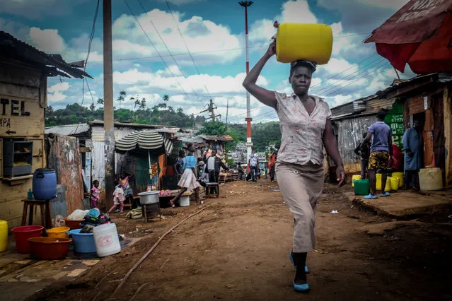 A woman carrying her can of water back home during the scarcity of water amidst the ongoing Curfew due to the corona virus pandemic in Nairobi, Kenya on May 5, 2020. Across most neighborhoods and the streets of Kibera, local residents are seen wandering around carrying their empty water cans in search of water while some have to queue up for a long period of time in parts where there is access to water. (Photo by Donwilson Odhiambo/SOPA Images/Rex Features/Shutterstock)