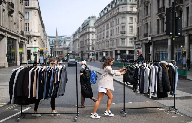 Retail workers move rails of clothes between stores on Oxford Street in London on June 12, 2020, as non essential retailers, made to close due to the COVID-19 pandemic, prepare to re-open on June 15. Britain's economy shrank by more than a fifth in April from March, official data showed Friday, as the first full month of coronavirus lockdown ravaged activity.  Gross domestic product nosedived by a record 20.4 percent from the previous month, after a 5.8-percent contraction in March, the Office for National Statistics said. (Photo by Daniel Leal-Olivas/AFP Photo)