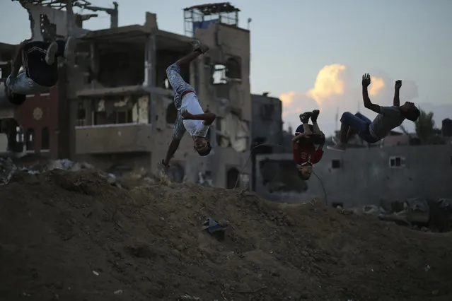 Palestinian youths practice their Parkour skills near the ruins of houses, which witnesses said were destroyed during a seven-week Israeli offensive, in the Shejaia neighborhood east of Gaza City October 1, 2014. (Photo by Mohammed Salem/Reuters)