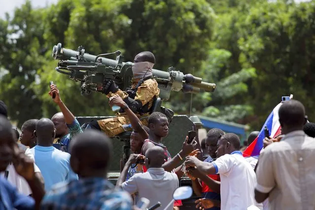 Soldiers loyal to Capt. Ibrahim Traore are cheered in the streets of Ouagadougou, Burkina Faso, Sunday, October 2, 2022. Burkina Faso's new junta leadership is calling for calm after the French Embassy and other buildings were attacked. (Photo by Kilaye Bationo/AP Photo)