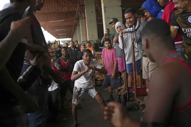 Cart pushers clench their fists threatening to start a fight after their carts accidentally colliding into each other at the Cease wholesale market in Rio de Janeiro, Brazil, Thursday, September 29, 2022. (Photo by Matias Delacroix/AP Photo)