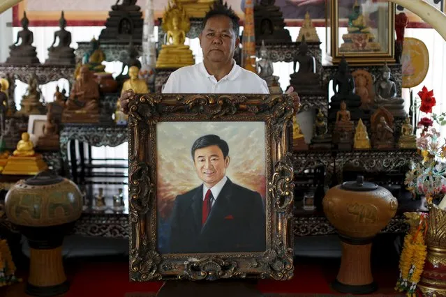 Red shirt movement leader Kwanchai Praipana poses with a photo of former PM Thaksin Shinawatra at his office in Udon Thani, Thailand, September 15, 2015. (Photo by Jorge Silva/Reuters)